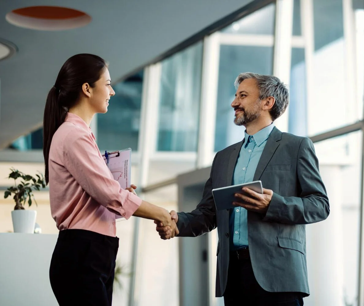 Consultant shaking hands with a client in office